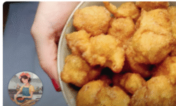 un cuenco lleno de buñuelos de viento hasta arriba, sujetados por una mano de mujer