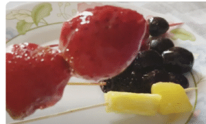 plato con brochas de frutas caramelizadas como fresas y moras