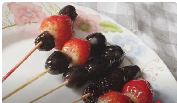 frutas caramelizadas insertadas en brochas de madera para que se enfrien