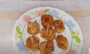 pequeñas porciones de leche frita puestos en un plato con un palillo cada una, para comerlas de bocado