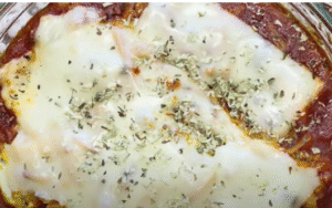 bol lleno de lasaña de calabacin y atun con queso derretido
