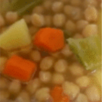 detalle de plato servido con cocido andaluz con garbanzos, caldo, patata y verduras