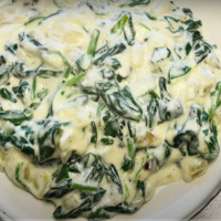 plato lleno de espinacas a la crema humeantes