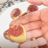 pasta casera de leche condensada con mermelada de fresa mostrada en detalle por una mano