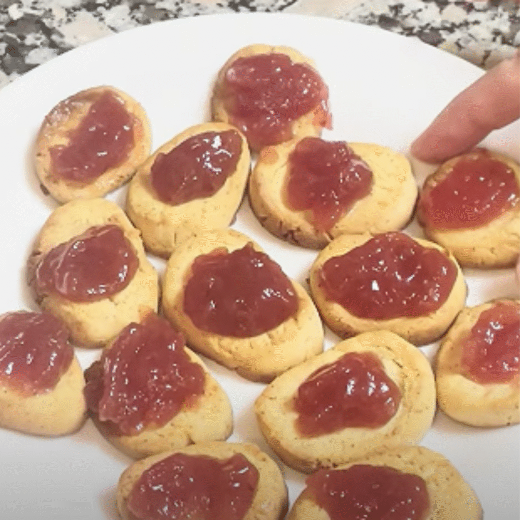 pasta casera de leche condensada con mermelada de fresa mostrada en detalle por una mano