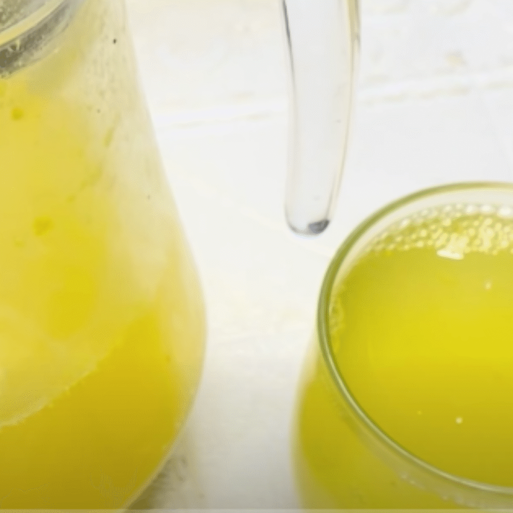 jarra y vaso con refresco de naranja casero