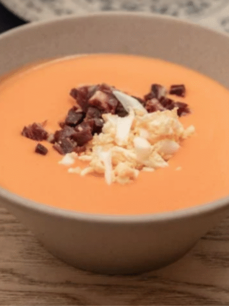 tazón con salmorejo con huevo duro y jamon picados