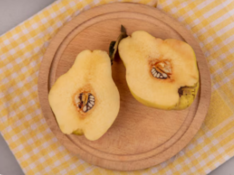 membrillo cortado por la mitad sobre tabla de cortar