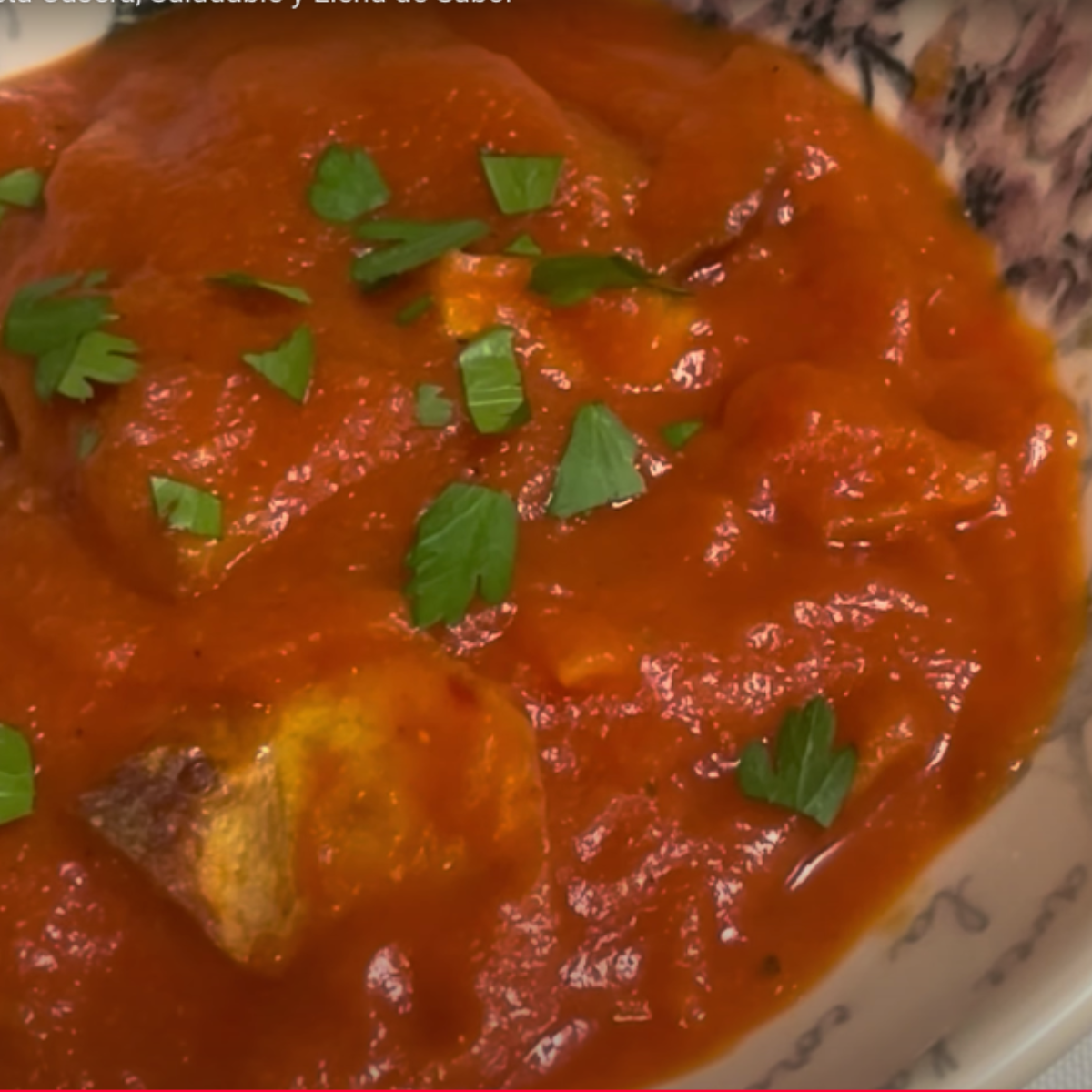 cuenco lleno de calabaza con tomate y patatas y un poco de perejil por encima