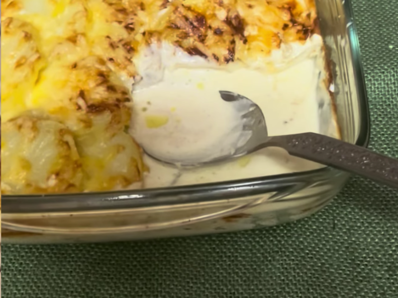 bandeja de gratinado de patata y berenjena donde se ha retirado una porción