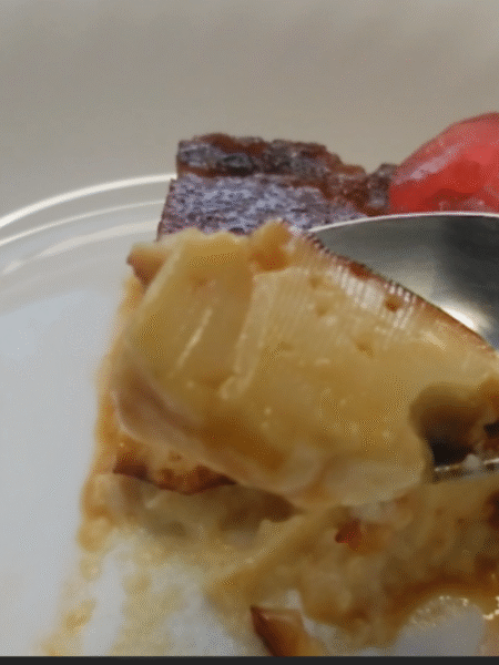 porcion triangular de flan servido en plato blanco con una guinda