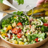ensalada con garbanzos, tomate, lechuga y otros aliñada con aceite