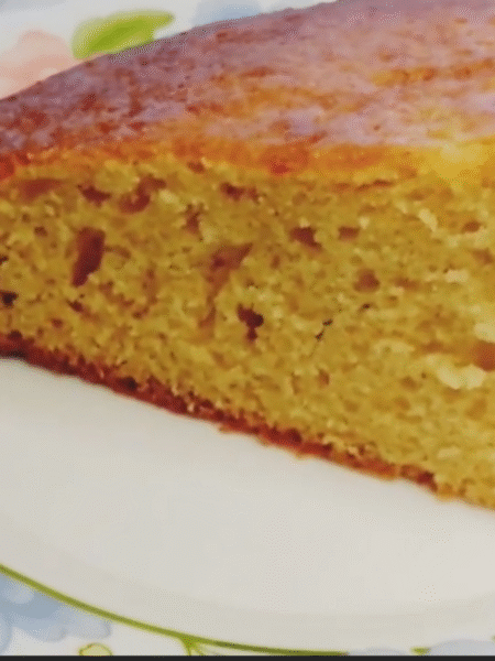 bizcocho redondo dorado, se está cortando una porción con un cuchillo