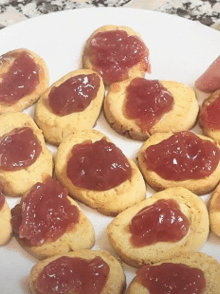pasta casera de leche condensada con mermelada de fresa mostrada en detalle por una mano