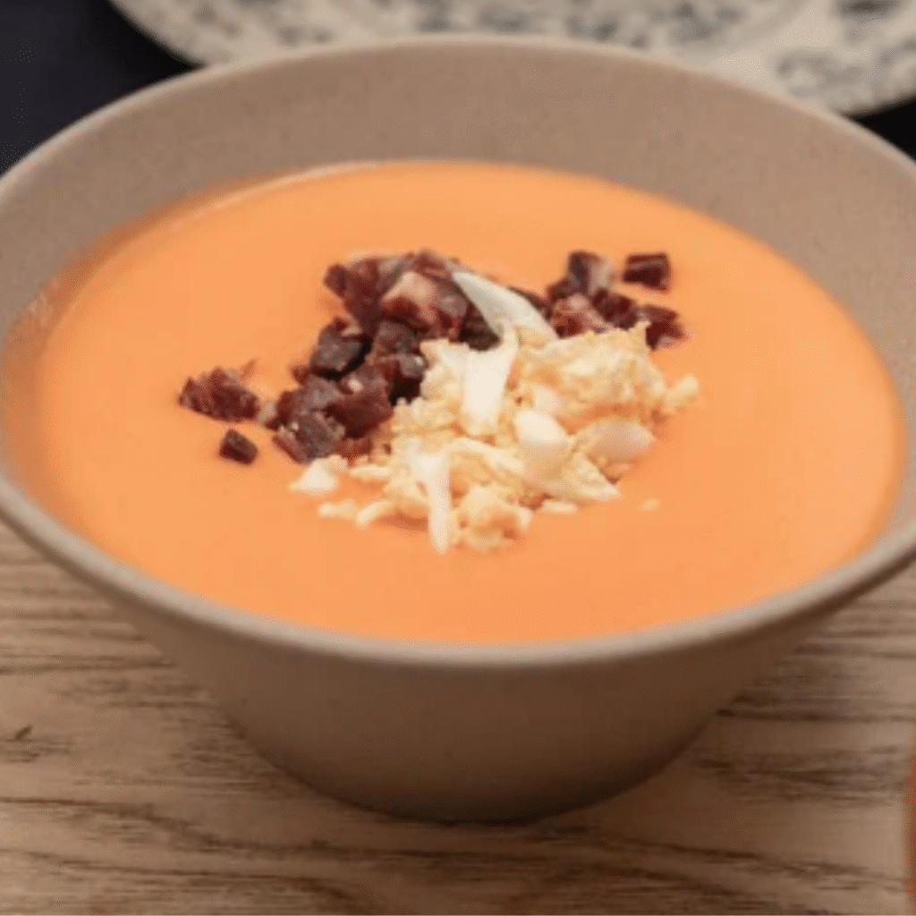 tazón con salmorejo con huevo duro y jamon picados