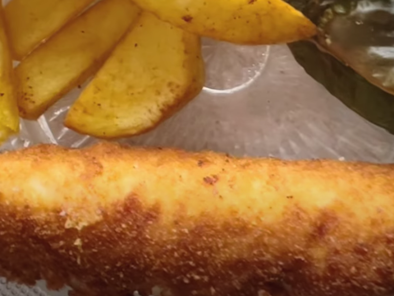 flamenquin de pollo servido con patatas y pimientos fritos