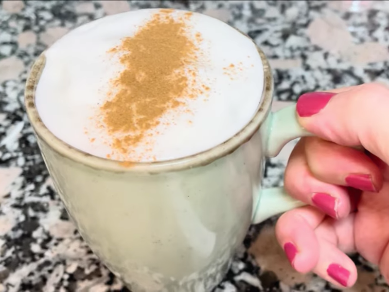 leche merengada en taza de cerámica con canela por encima
