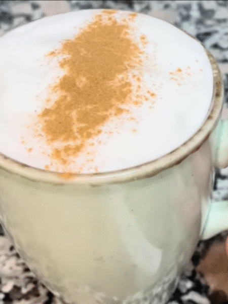 leche merengada servida en taza de cerámica verde con canela por encima