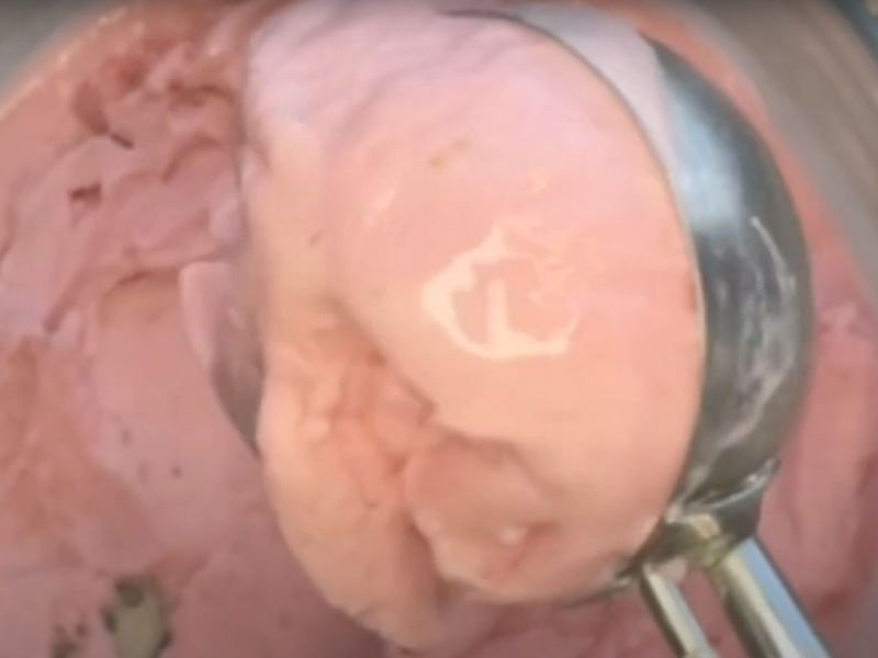 se toma una porción de helado de fresa