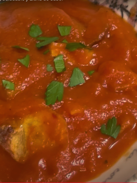 cuenco lleno de calabaza con tomate y patatas y un poco de perejil por encima