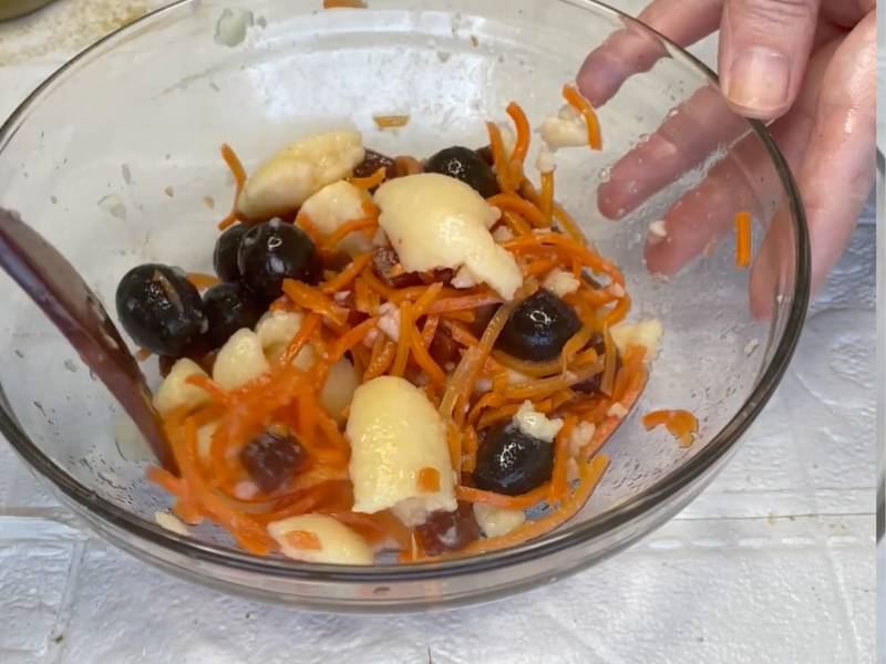 mezclando ensalada de patata, zanahoria y remolacha con cuchara de madera